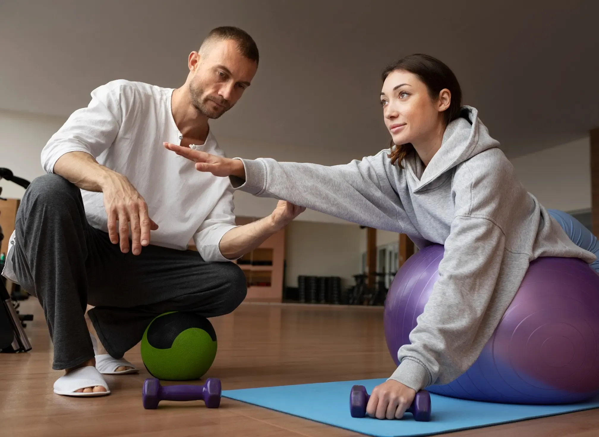 A patient using rehabilitation equipment with a therapist nearby